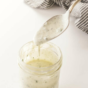 a mason jar of buttermilk ranch salad dressing and a spoon