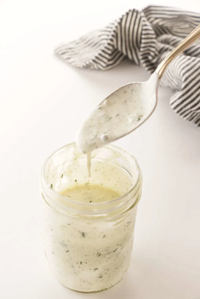 a mason jar of buttermilk ranch salad dressing and a spoon