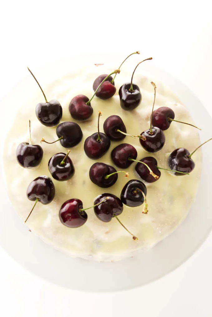 Overhead view of fresh cherry cake covered with white chocolate ganache