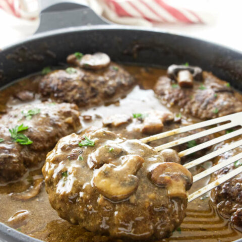 Salsbury steak being lifted from skillet