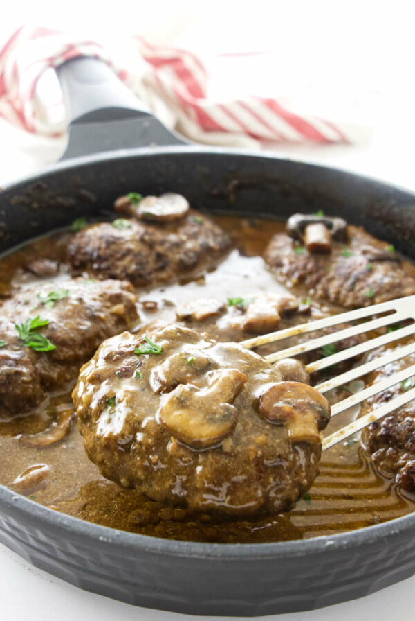 Salsbury steak being lifted from skillet