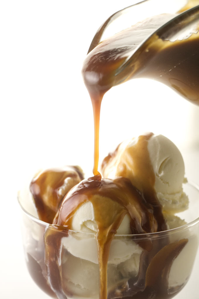 Drizzling butterscotch sauce over ice cream.
