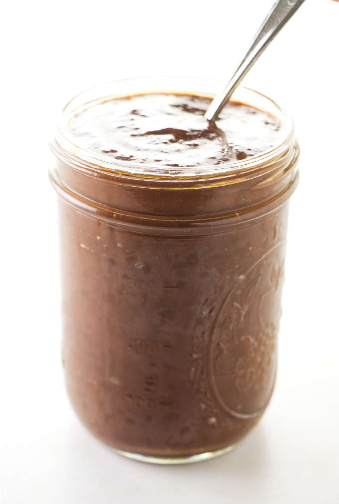 A spoon in a jar of chipotle barbecue sauce. 