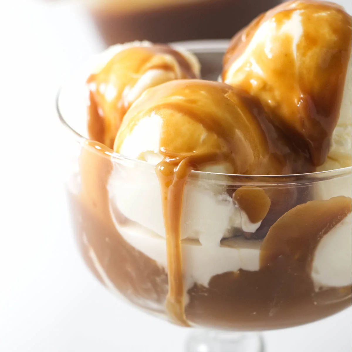 A bowl of ice cream with butterscotch sauce on top.