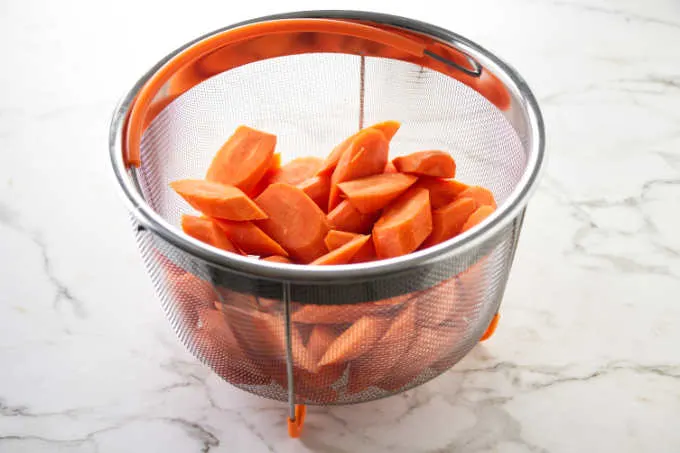 Carrot slices in a steamer basket that fits the Instant Pot.