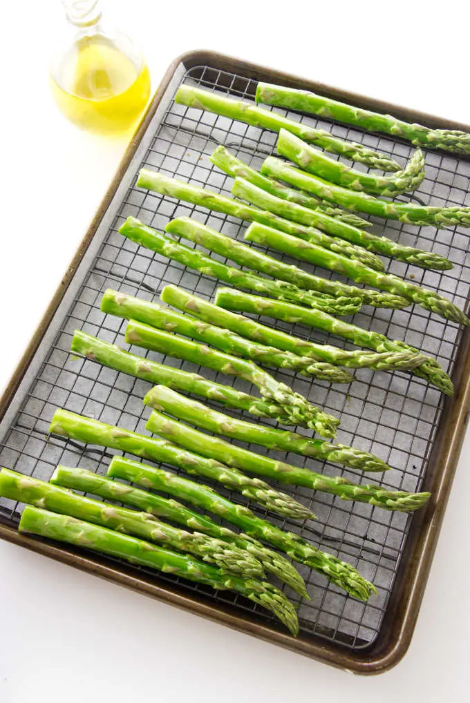 A baking sheet with asparagus ready for the oven.