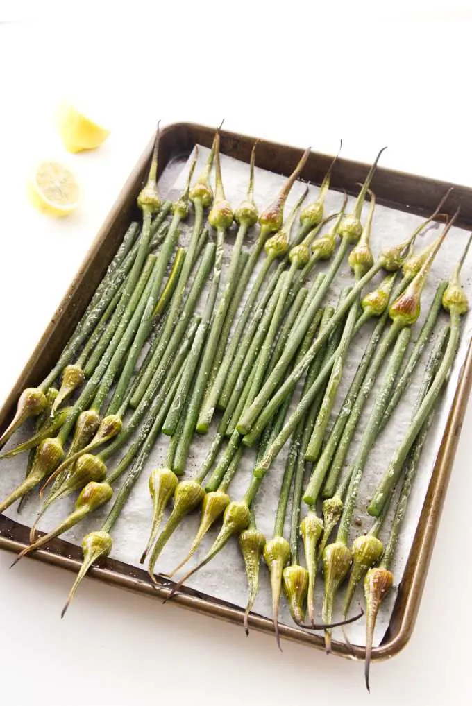 Roasted garlic spears on a baking sheet.