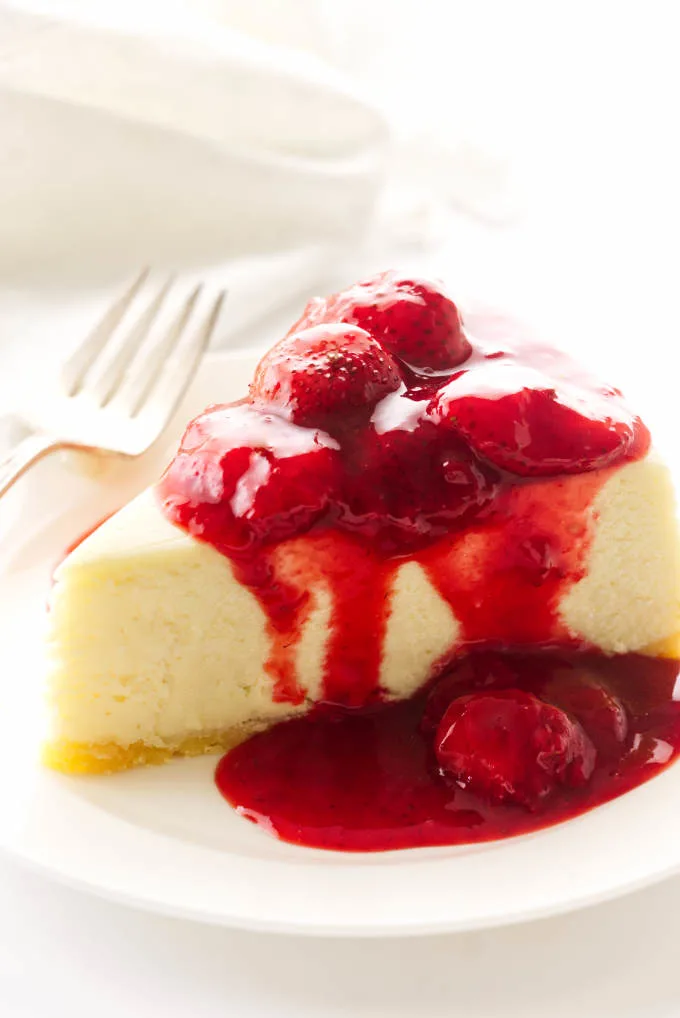 A serving of cheesecake with strawberry topping