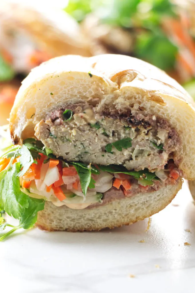 A chicken banh mi sandwich sliced in half.