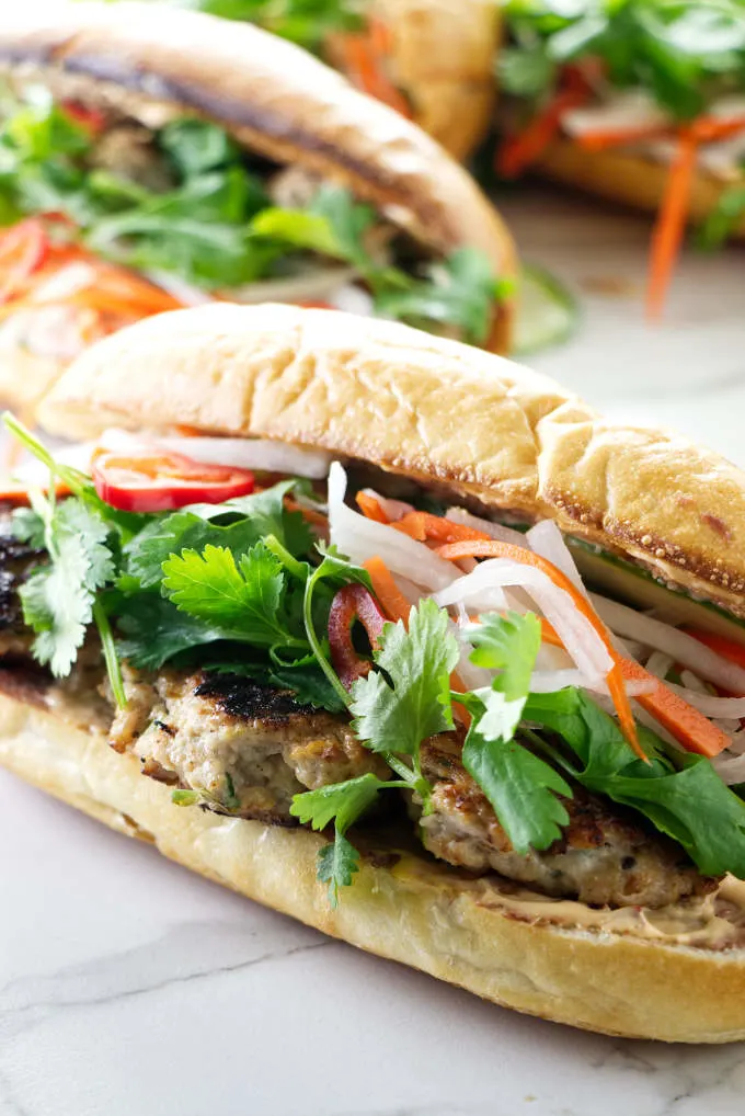A chicken meatball banh mi sandwich on a French baguette roll.