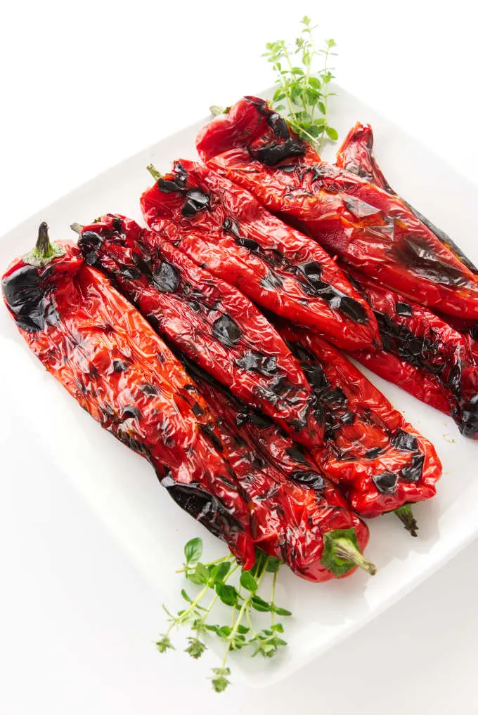 A serving plate filled with grilled Italian sweet peppers.