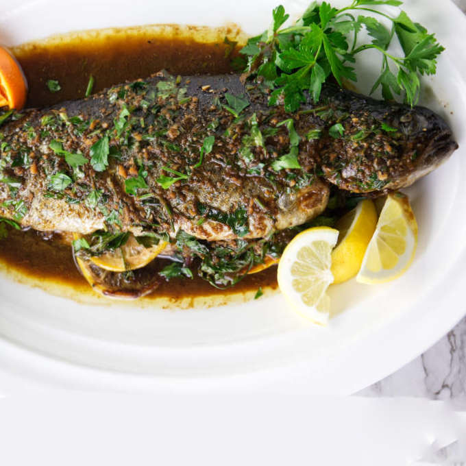 A whole baked rainbow trout with citrus pan sauce.
