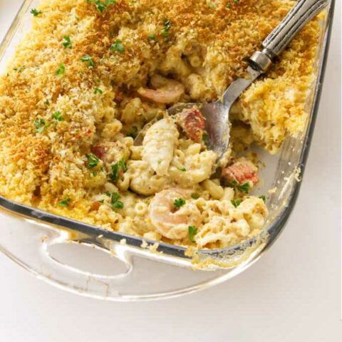 A casserole dish with baked seafood mac and cheese.