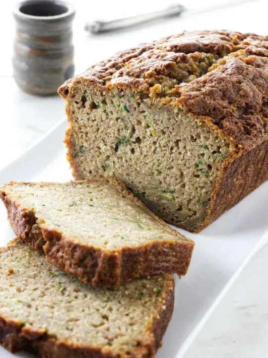 A loaf of zucchini bread with two slices taken off the end.