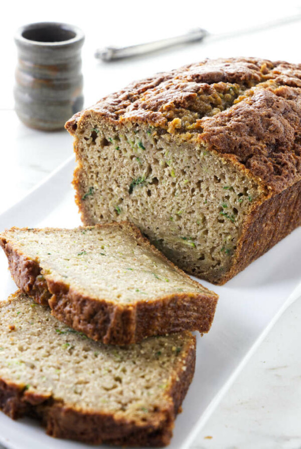 A loaf of zucchini bread with two slices taken off the end.