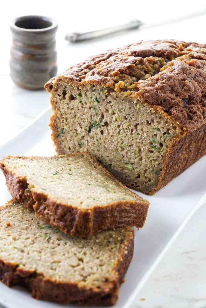 A loaf of zucchini bread with two slices taken off the end.