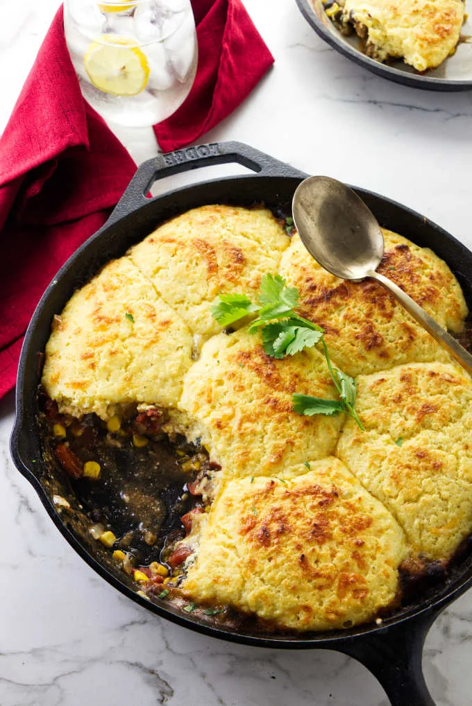 Mexican casserole with a cornbread topping in a cast iron skillet.