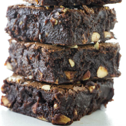 A stack of brownies with almond chunks.
