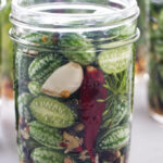 Cucamelons and spices in a jar with pickling brine.