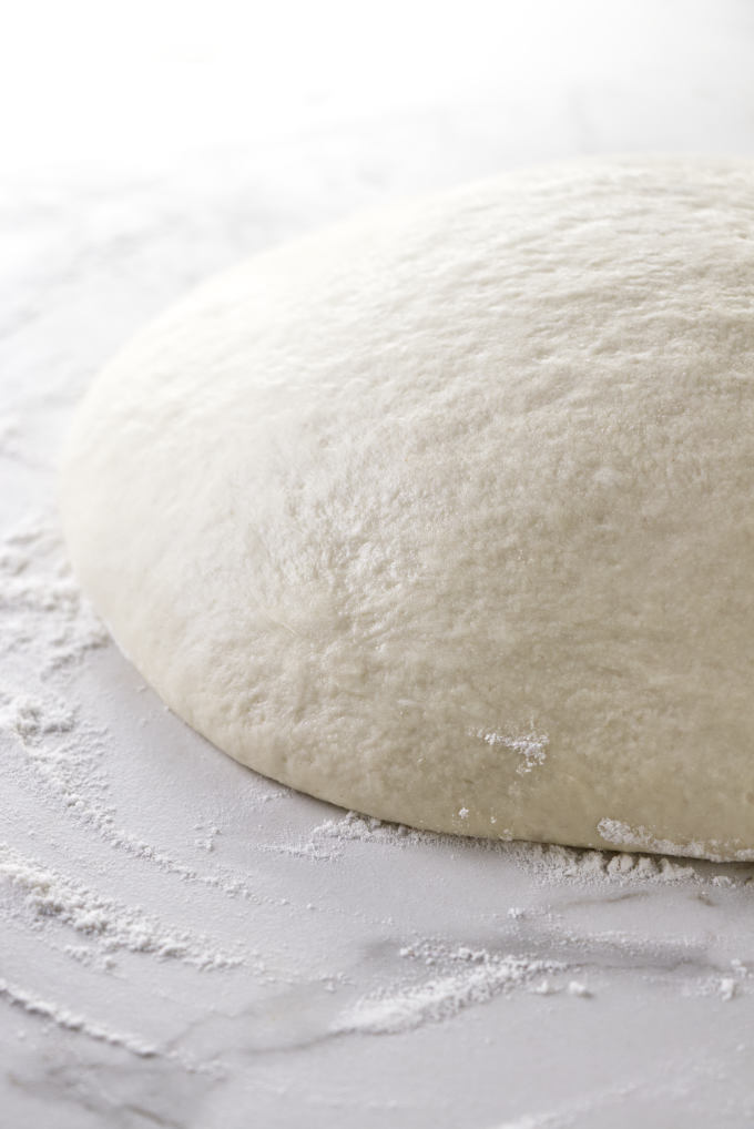 Pizza dough rising on the counter.