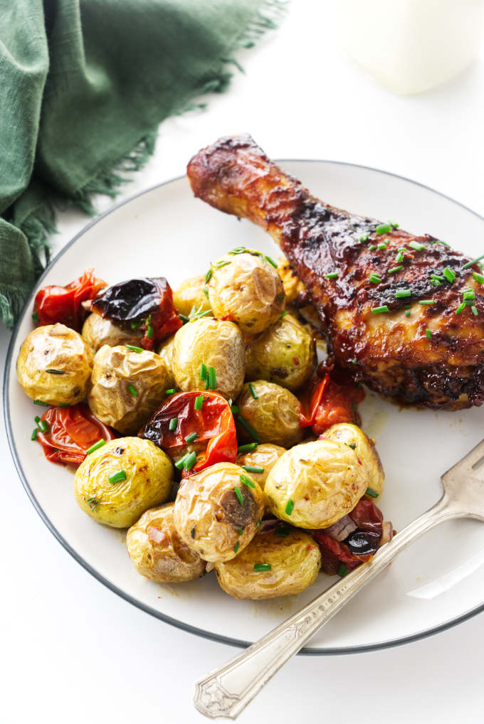 Roasted potato salad on a plate with bbq chicken.