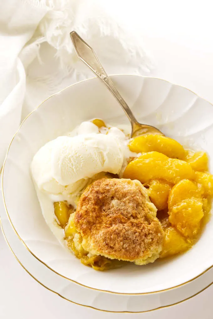 Serving of skillet peach cobbler with ice cream