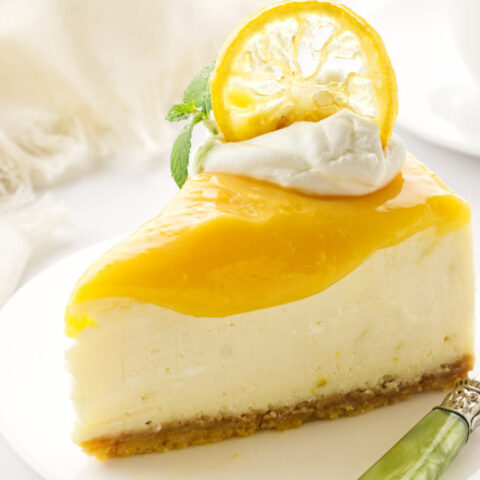 a serving of triple lemon cheesecake on a plate with green fork