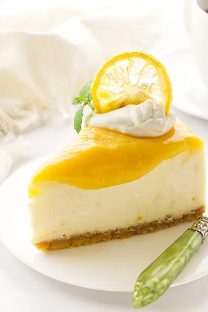 a serving of triple lemon cheesecake on a plate with green fork