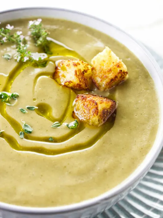 Zucchini garlic soup with a swirl of olive oil on top.