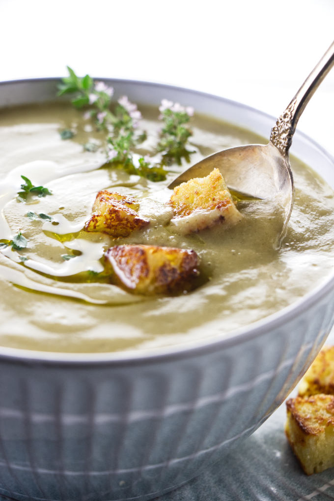 A bowl of zucchini garlic soup garnished with croutons.