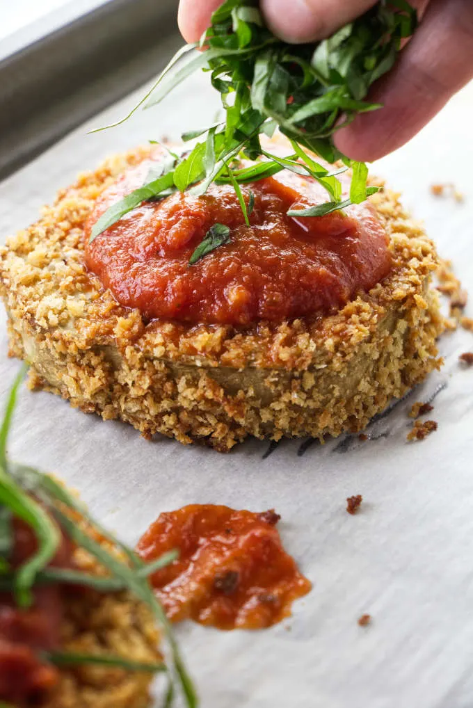 Topping eggplant slices with basil.