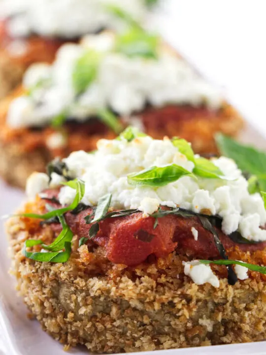 Baked eggplant steaks topped with marinara sauce and goat cheese.