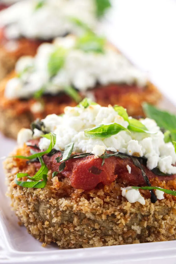 Baked eggplant steaks topped with marinara sauce and goat cheese.