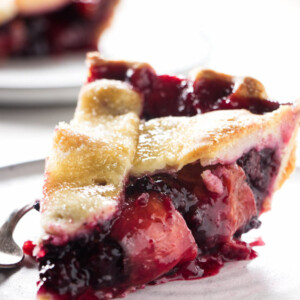 A slice of blackberry peach pie on a plate.