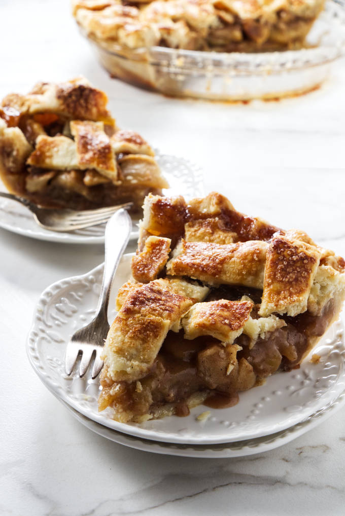 Two slices of caramel apple pie on dessert plates.