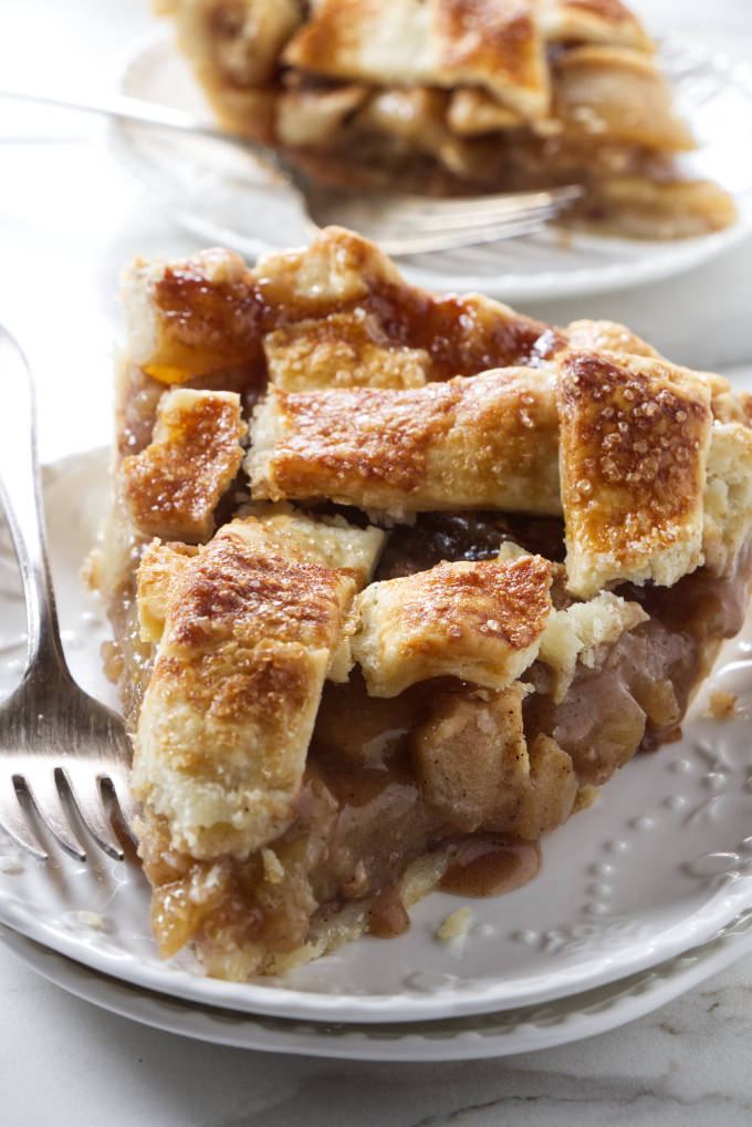 A slice of caramel apple pie on a dessert plate.