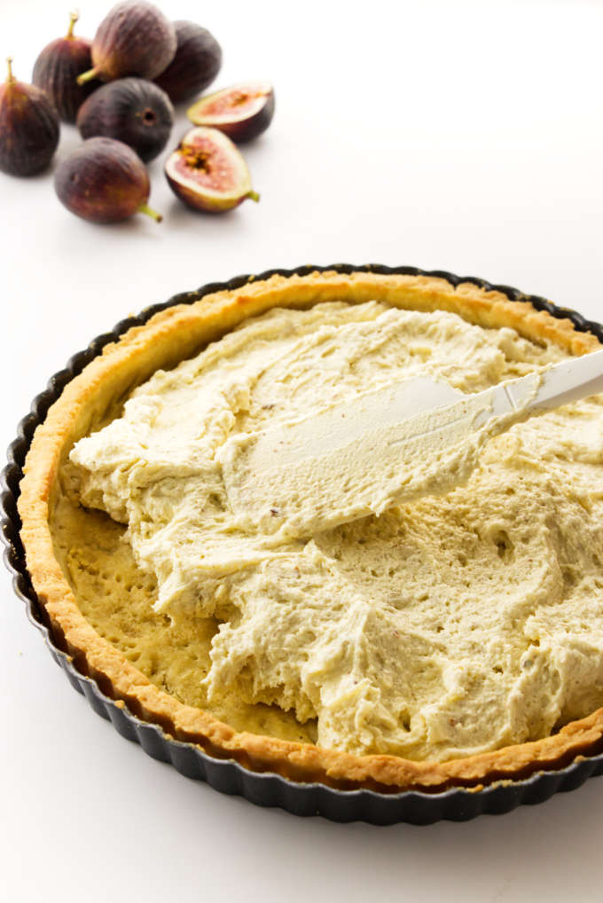 Frangipane mixture being smoothed into a baked shortbread crust