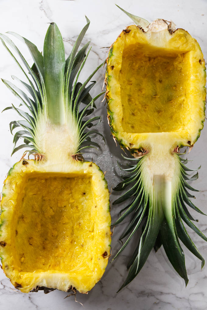 Two halves of a pineapple carved out to make pineapple bowls.