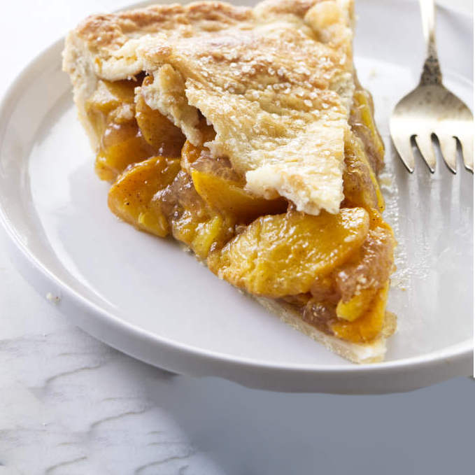 A slice of peach pie with brown butter and bourbon.
