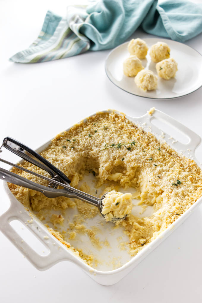 Baked mac 'n cheese being scooped out into appetizer bites