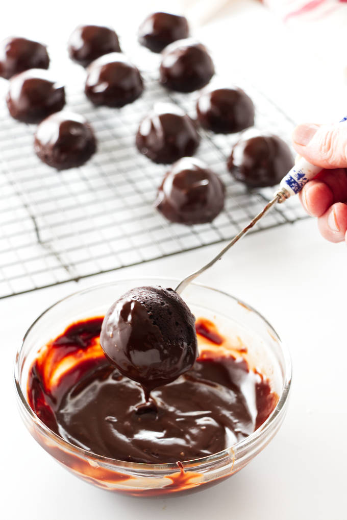 Baked miso brownie bite being dipped in ganache glaze