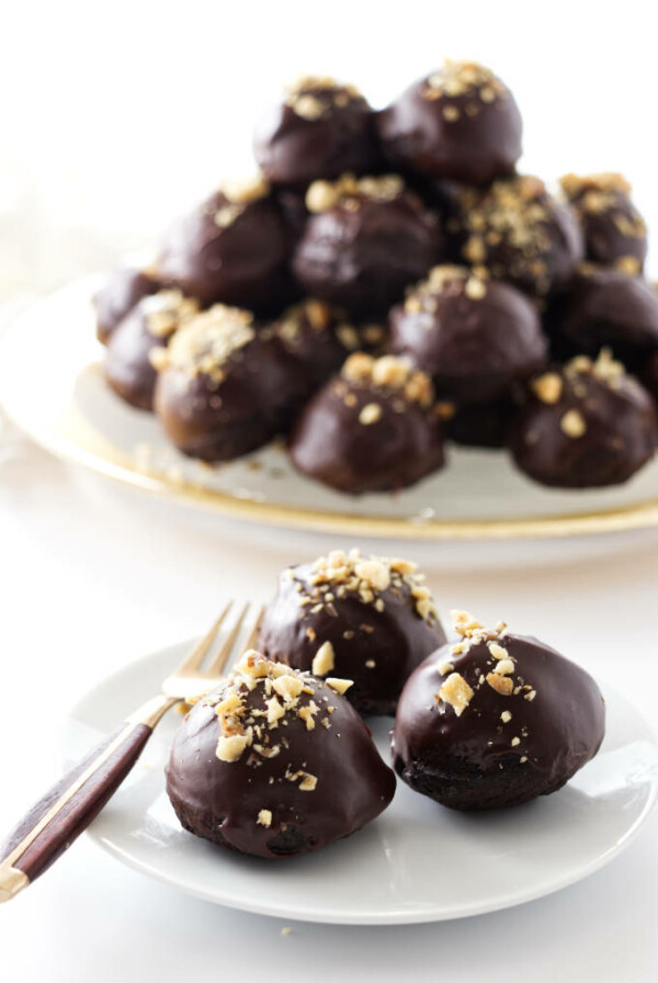 3 miso brownie bites and a fork on a plate- pile of brownie bites on a platter in background