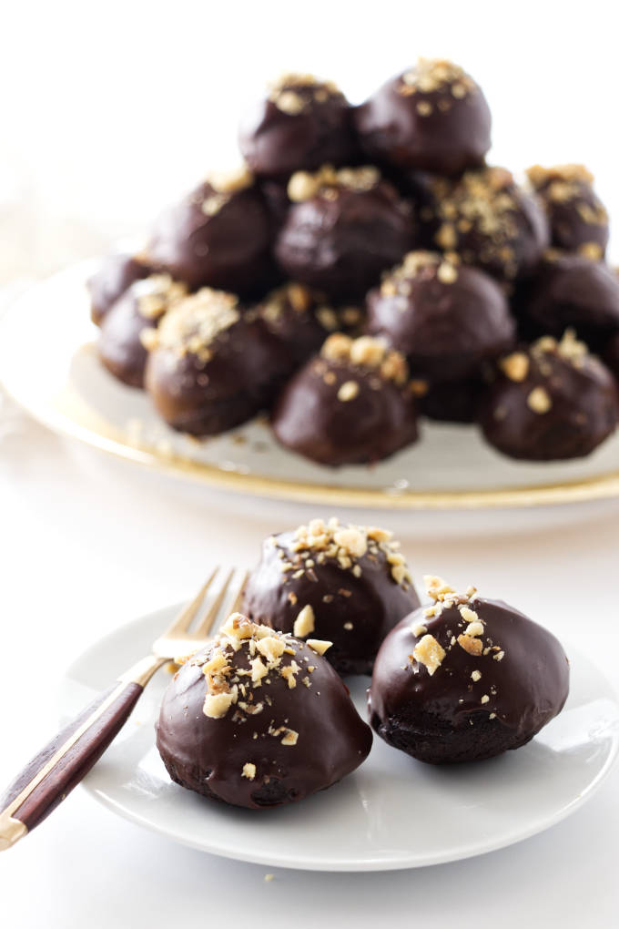 3 miso brownie bites and a fork on a plate- pile of brownie bites on a platter in background