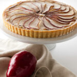 A pear frangipane tart on a dessert platter.