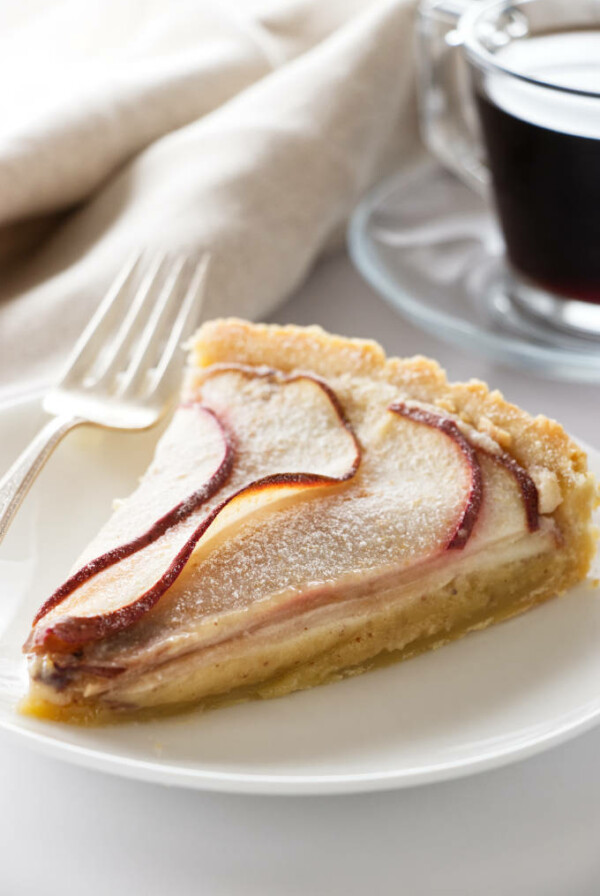 A slice of pear frangipane tart on a dessert plate.