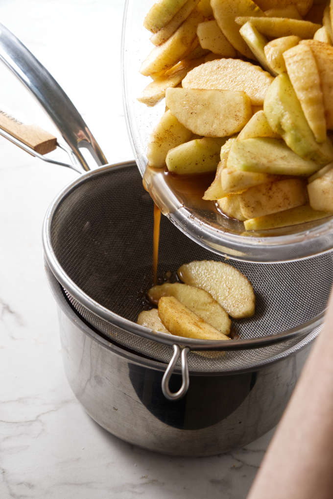 straining fruit juice into a sauce pan.