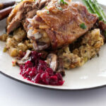 close up view of a serving of roasted turkey thigh with mushrooms stuffing