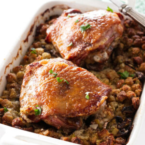 Casserole dish with stuffing topped with two turkey thigs