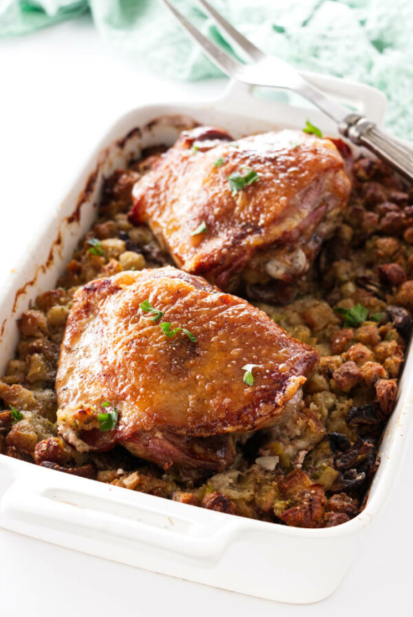 Casserole dish with stuffing topped with two turkey thigs