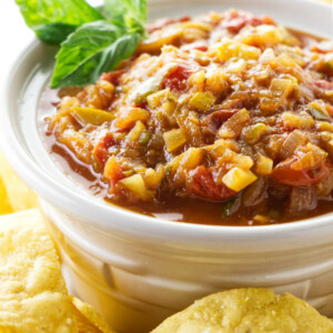 Zucchini salsa in a dish next to tortilla chips.